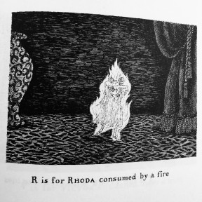 Black and white illustration taken from “The Gashlycrumb Tinies” of a little girl surrounded by a large flame in an otherwise dark room. It is captioned “R is for Rhoda consumed by a fire."